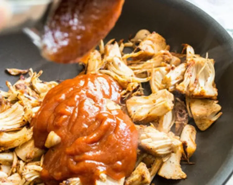 Step 3.1: Add coconut oil and seasoned jackfruit to a pan and cook on medium heat for 4-5 minutes, or until the jackfruit begins to color