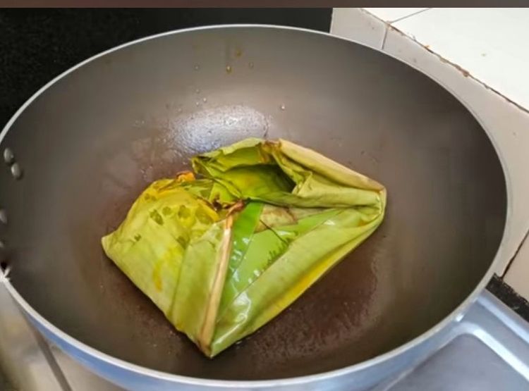 Step 4.1: Add 1 tbsp oil to a pan and place the wrapped fish in it
