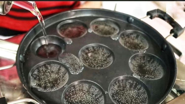 Step 1.1: After 8 hours, heat the unniyappam pan and pour some oil into each mold