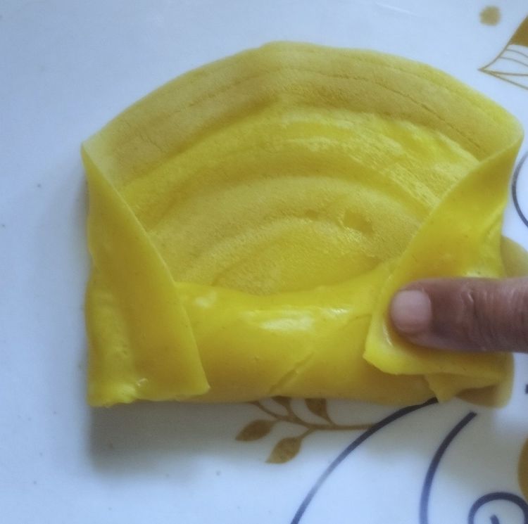 Step 4.2: Roll the crepe once, then fold the ends inward and continue rolling