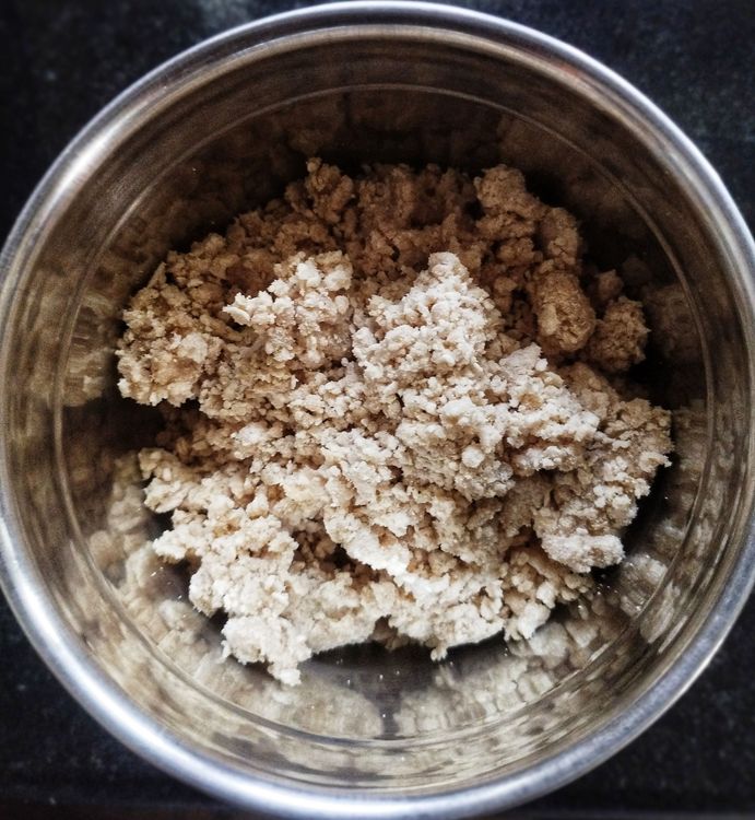 Step 1.1: Add 3-4 tbsp of the wet flour to a mixer jar or food processor, add 2 tsp of dry wheat flour, and pulse a couple of times to remove lumps and form soft puttu