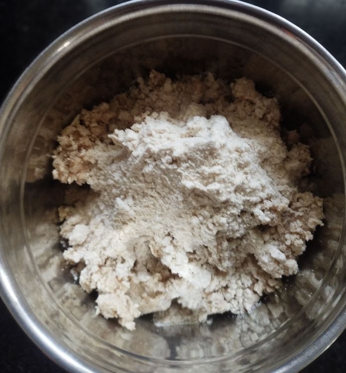 Step 1.2: Add 3-4 tbsp of the wet flour to a mixer jar or food processor, add 2 tsp of dry wheat flour, and pulse a couple of times to remove lumps and form soft puttu