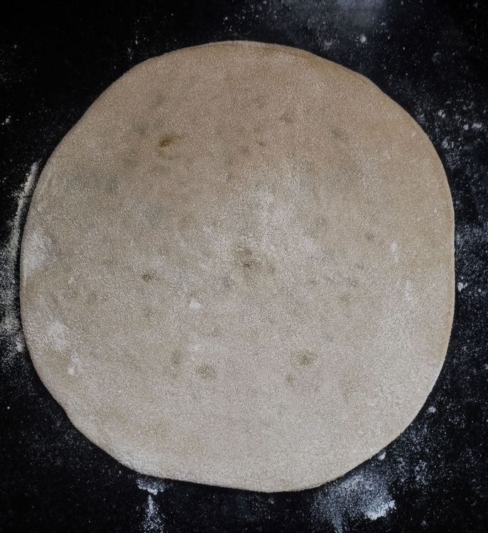 Step 3.1: Dust with flour and start rolling the paratha into a round shape, about 7 to 8 inches in diameter or about the size of normal chapati
