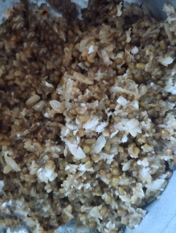 Step 4.1: In a mixing bowl, combine cooked green gram, jaggery syrup, grated coconut, cardamom powder, cumin seed powder, ghee, and flattened rice