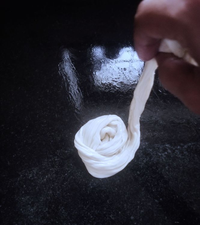 Step 2.2: Take the strips with your hand, pull slightly, and roll into a spiral