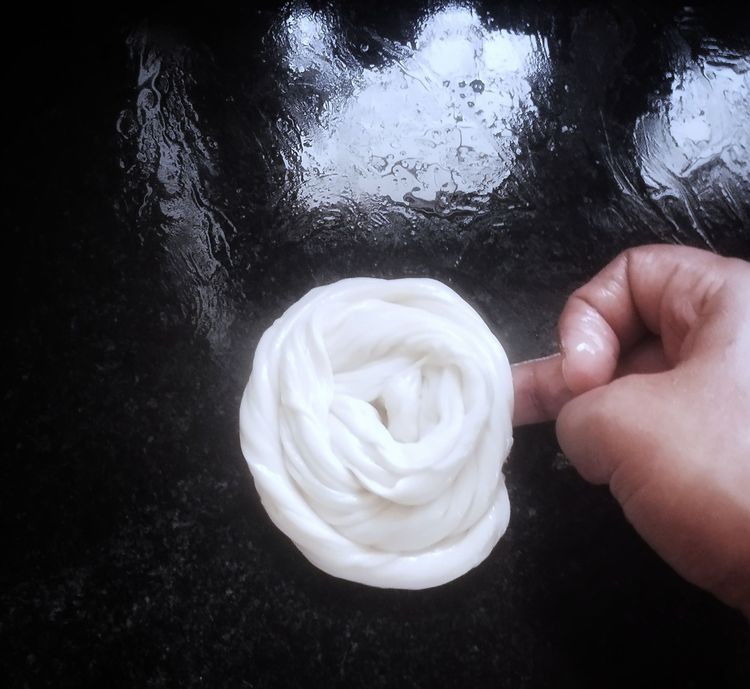 Step 2.3: Take the strips with your hand, pull slightly, and roll into a spiral