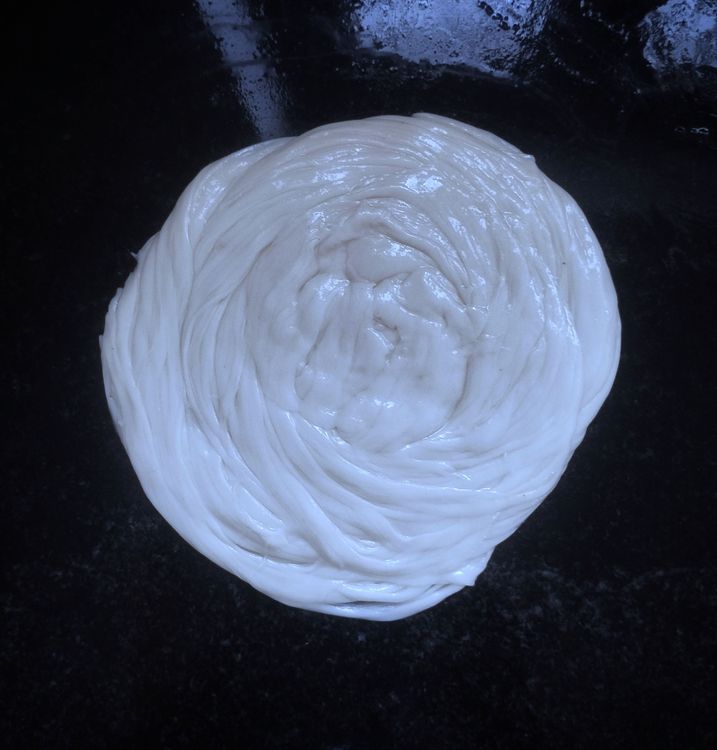 Step 3.1: Grease your hands, gently pat and spread the dough, and roll slightly thick, ensuring all layers are intact