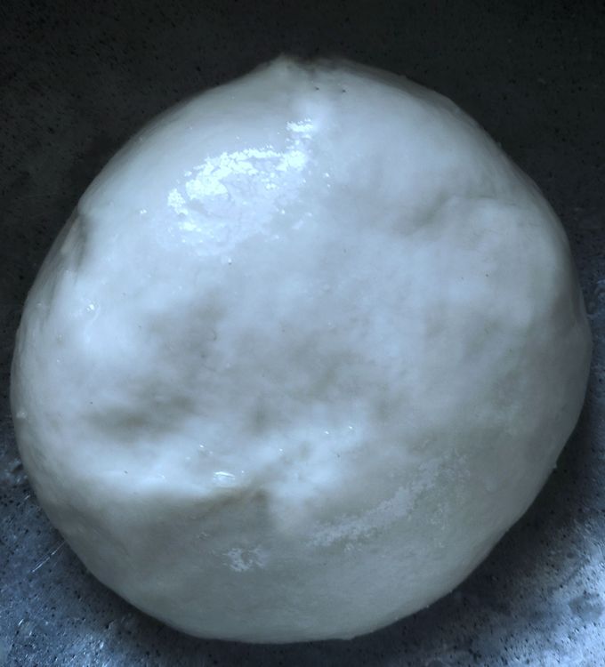 Step 2.1: Place the dough in a bowl, grease with the ghee-oil mix, and cover with a wet cloth