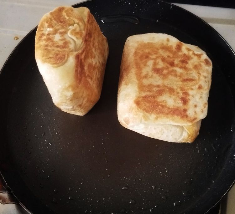 Step 2.2: Heat a pan, spread some oil, and place the parotta puffs