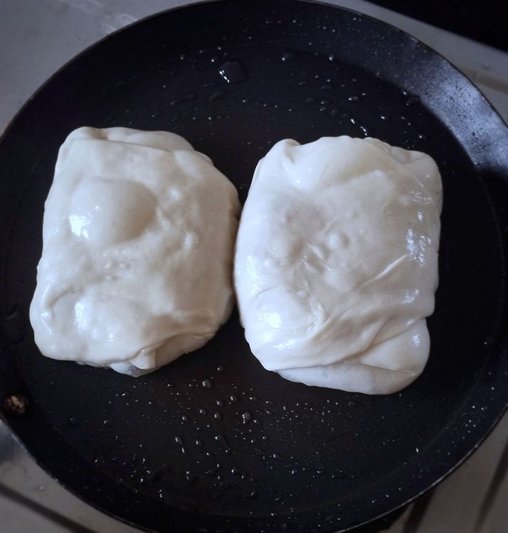 Step 2.1: Heat a pan, spread some oil, and place the parotta puffs