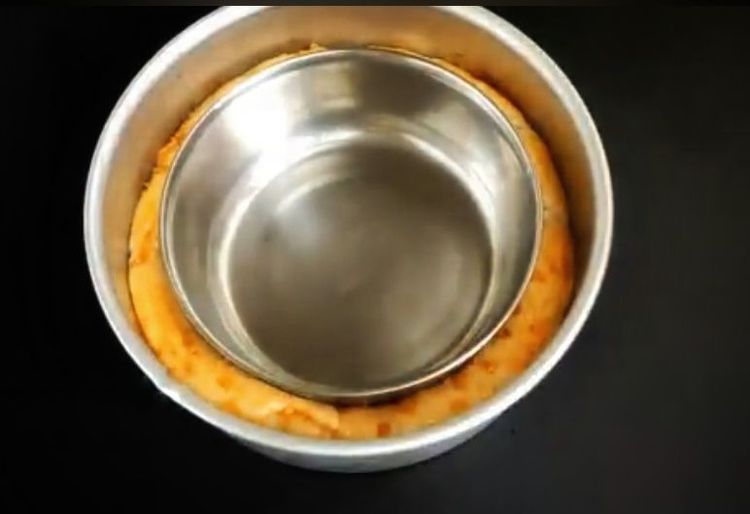 Step 1.1: Place a small greased bowl in the center of the dough and pour some water into it