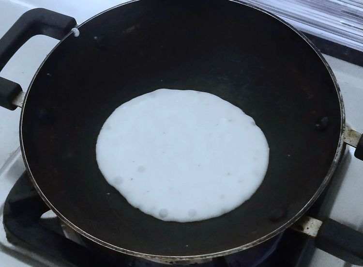 Step 1.1: Pour one ladle of batter into the pan and tilt it in a circular motion to spread the batter into a round shape