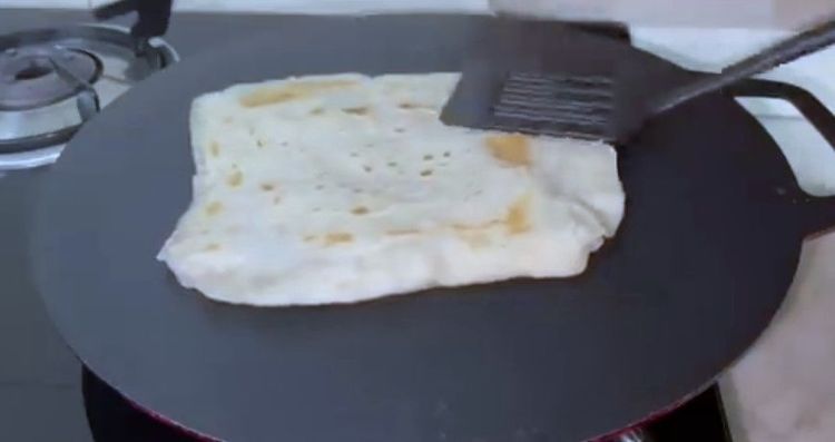 Step 1.2: When small bubbles appear, flip the roti