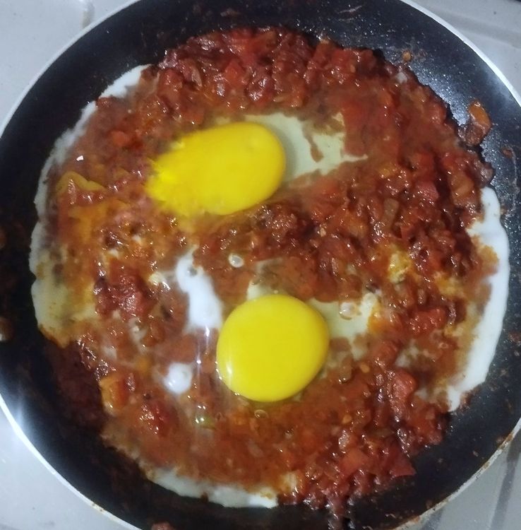 Step 1.1: Use a large spoon to make wells in the sauce and crack open the eggs into each well