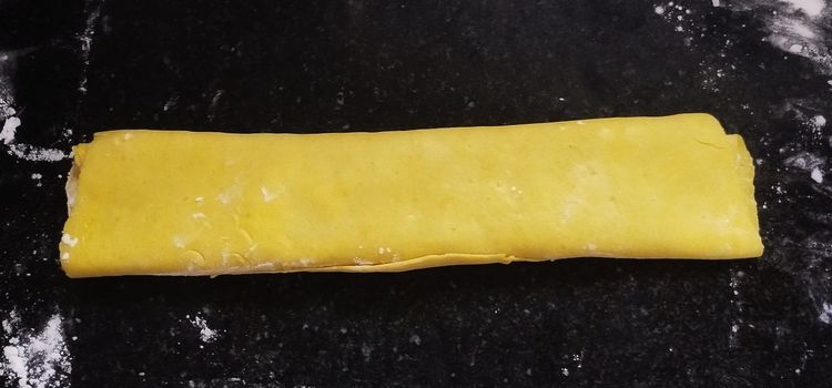 Step 2.3: Start rolling the layered sheets from one side into a log shape