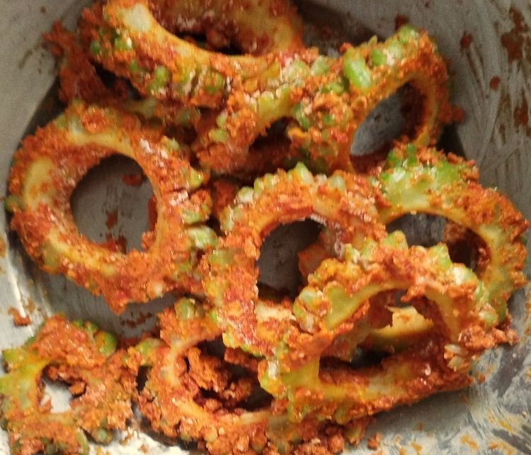 Step 1.2: Add chili powder, turmeric powder, amchur powder, garam masala powder, salt, chickpea flour, and corn flour to the rinsed bitter gourd slices
