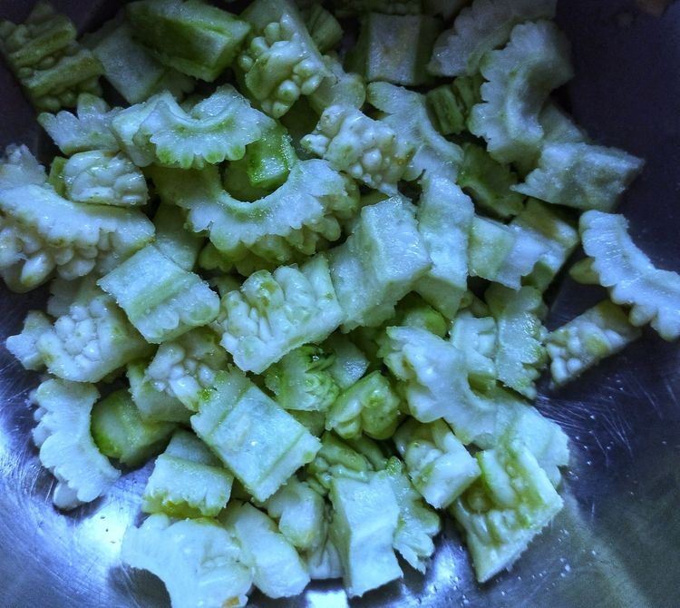Step 1.1: Cut the cleaned bitter gourd into small pieces and add them to a bowl with 1 tbsp of salt