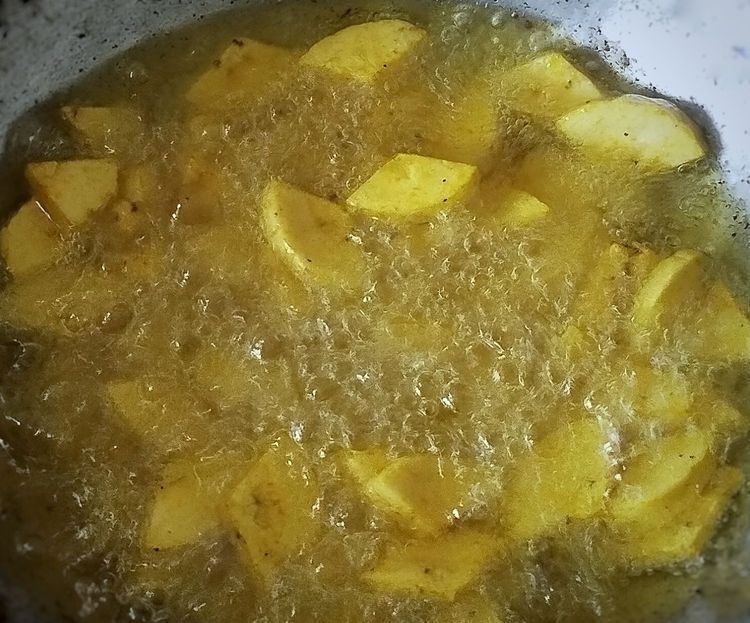 Step 1.1: When the oil becomes hot, add the drained banana pieces and fry on medium flame until crispy