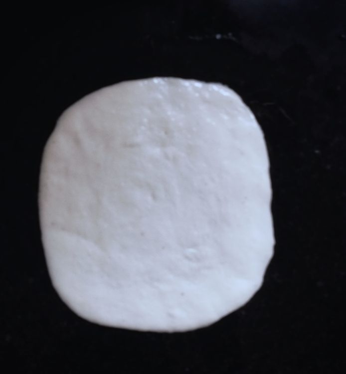 Step 1.1: Roll out each ball into an oval or round disc, about 6-7 inches wide