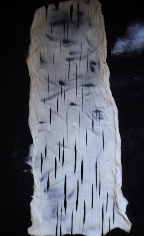 Step 2.1: Fold into a roll, then gently stretch it and shape into a coil, and gently flatten again into a paratha shape
