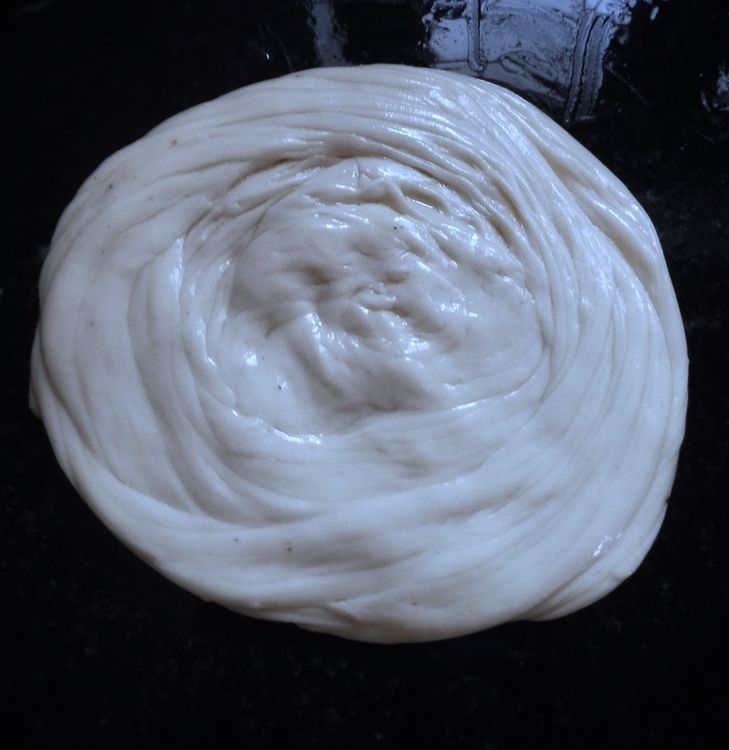 Step 2.4: Fold into a roll, then gently stretch it and shape into a coil, and gently flatten again into a paratha shape