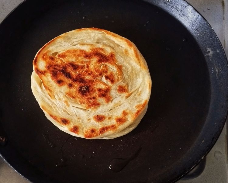 Step 3.1: Brush with ghee and cook until golden brown and flaky