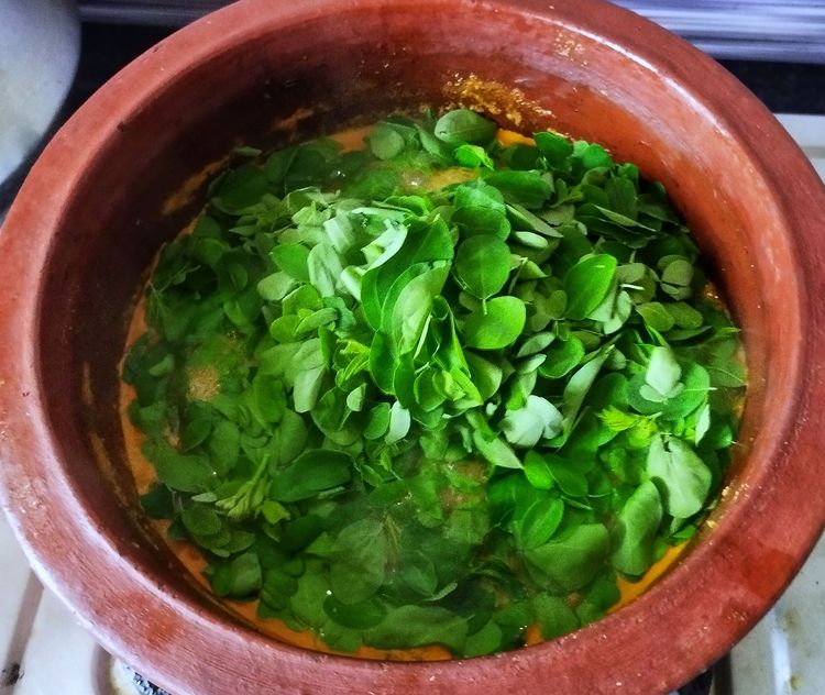 Step 4.1: Add the cleaned moringa leaves, stir well, and cook covered for 4–5 minutes