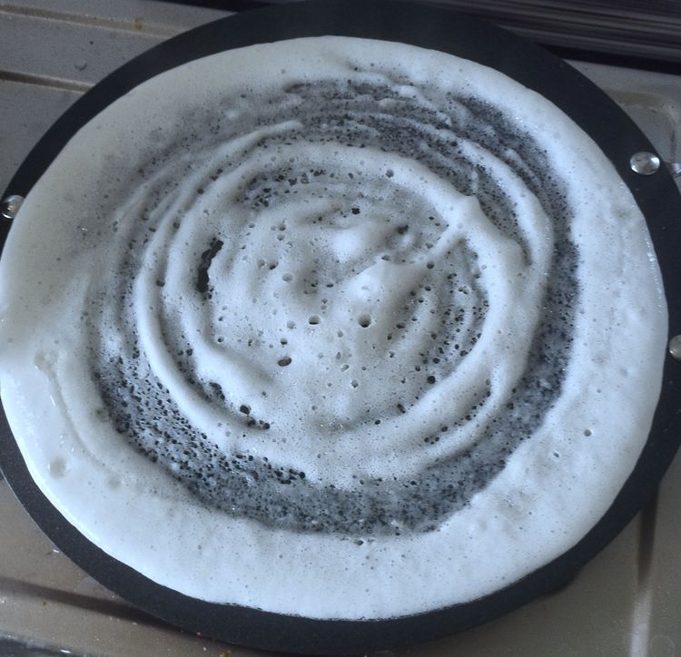 Step 4.1: Pour a ladle of batter and spread in a circular motion to make a thin dosa