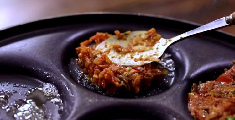 Step 3.3: Place a spoonful of prepared onion-tomato masala into each mould and gently press to level it