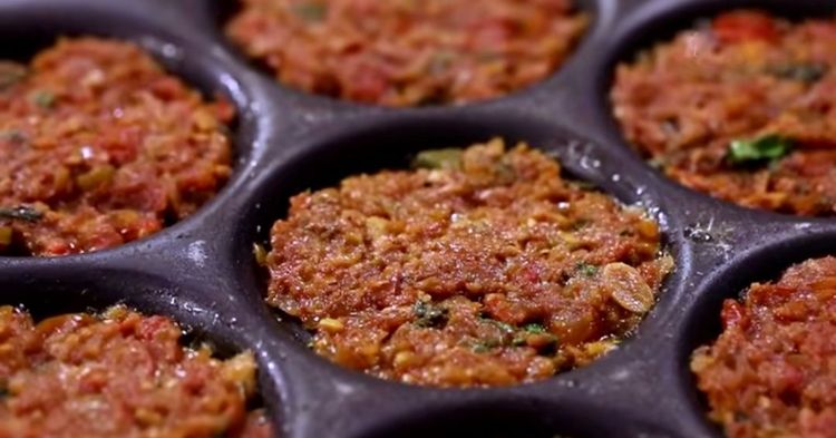 Step 3.4: Place a spoonful of prepared onion-tomato masala into each mould and gently press to level it