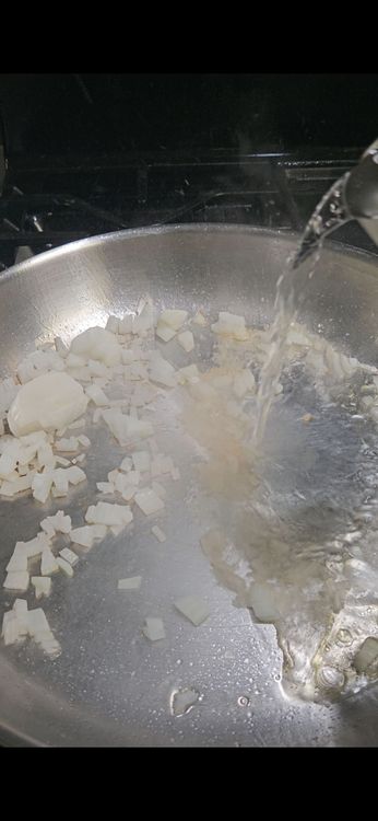 Step 1.1: Add the white wine to the pan and simmer until reduced by half, about 3–5 minutes
