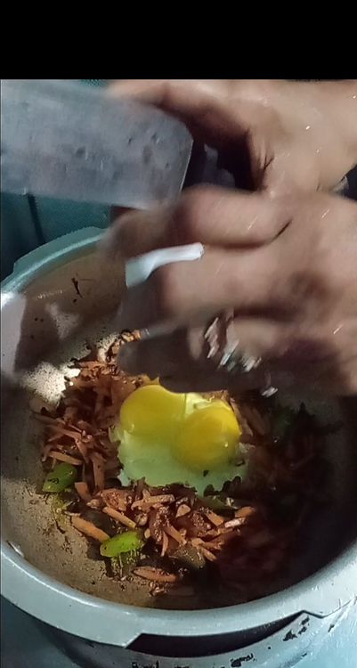 Step 3.3: Push the vegetables to one side of the pan and pour in the beaten eggs on the other side