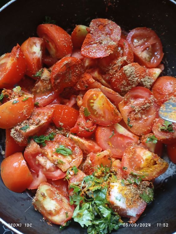 Step 1.1: In a kadai, add the tomatoes, turmeric powder, red chilli powder, salt, tamarind paste, garlic cloves, coriander leaves, and 100 mL of water