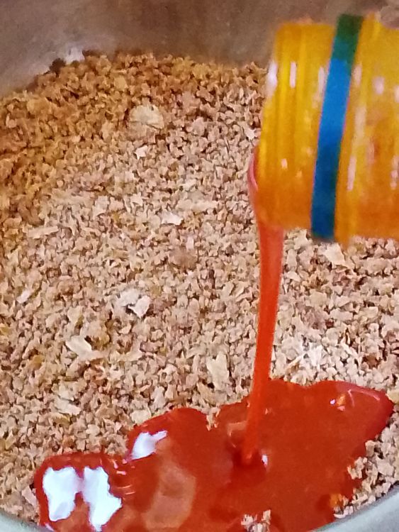Step 1.1: In a stainless plate, pour your grounded bush mango seeds (ogbono) and add enough palm oil to it and mix them together until it is properly mixed with the palm oil