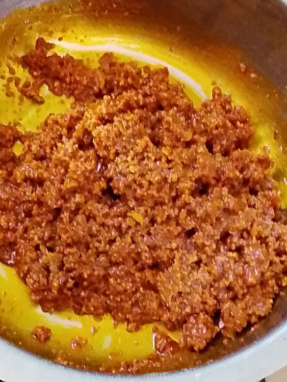 Step 1.2: In a stainless plate, pour your grounded bush mango seeds (ogbono) and add enough palm oil to it and mix them together until it is properly mixed with the palm oil