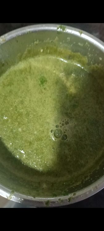 Step 1.1: In the same grinder, add onion, coriander, mint leaves, green chilli, cloves, pepper, and a little water to make a green paste