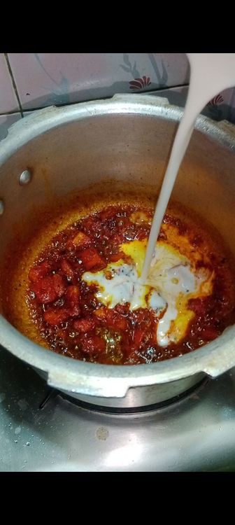 Step 1.2: Once tomato gets properly mashed with masalas , add beaten homemade curd, mix well and simmer for 2 min till oil separates