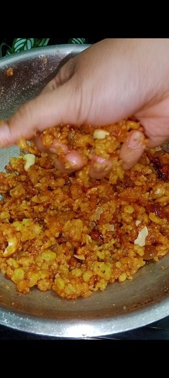 Step 3.1: When the mixture is warm (not too hot or cold), grease your hands with ghee and shape the boondi into small, round laddus