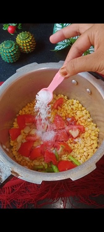 Step 2.2: Add chopped tomatoes , green chillies and crushed garlic pods ( this gives a nice aroma to dal ) followed by salt and sufficient water to cook dal ( for  1 cup toor dal I used 2 cups water )