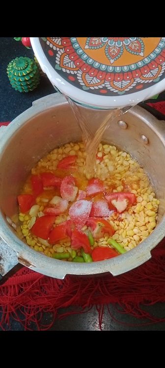 Step 2.3: Add chopped tomatoes , green chillies and crushed garlic pods ( this gives a nice aroma to dal ) followed by salt and sufficient water to cook dal ( for  1 cup toor dal I used 2 cups water )