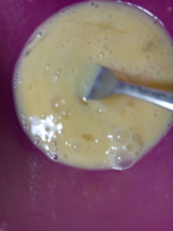 Step 1.2: In a smaller bowl, break in the eggs and add the milk essence