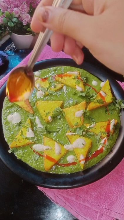 Step 5.3: In a plate , spread the prepared palak paste, place the tossed paneer cubes , garnish some coriander leaves, drizzle some white paste and red chilli oil