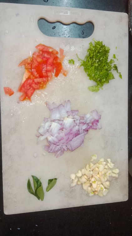 Step 1.1: Finely chop the onion, tomato, garlic pods, and coriander leaves