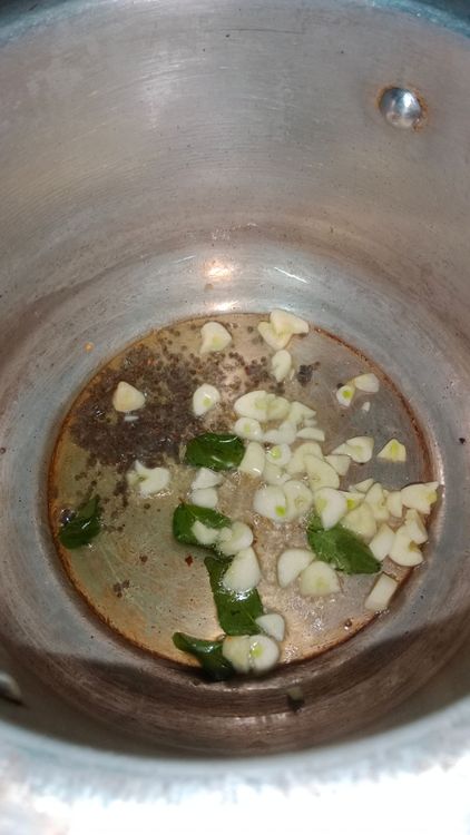 Step 2.1: Heat oil in a pressure cooker and temper mustard seeds, curry leaves, and chopped garlic pods