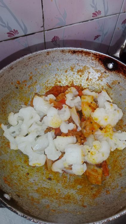 Step 1.1: Once the oil separates and the tomato moistens completely, add diced boiled potato and blanched cauliflower florets