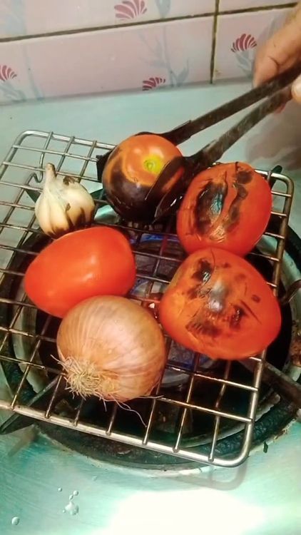 Step 1.1: Roast the tomatoes, onion, and whole garlic until the surface turns slightly black over an open flame on wire gaze