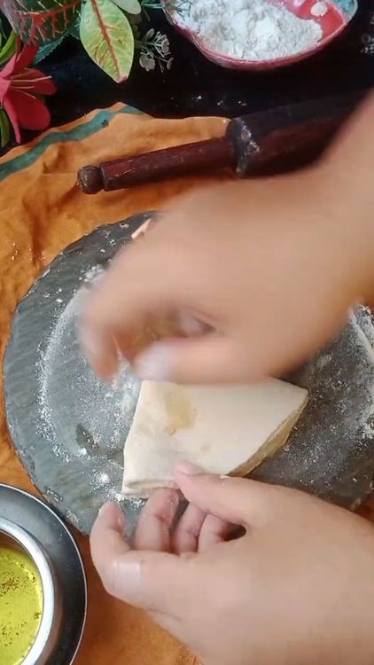 Step 2.1: Fold the roti into a semi-circle, then fold again into a triangle (like making a samosa base)