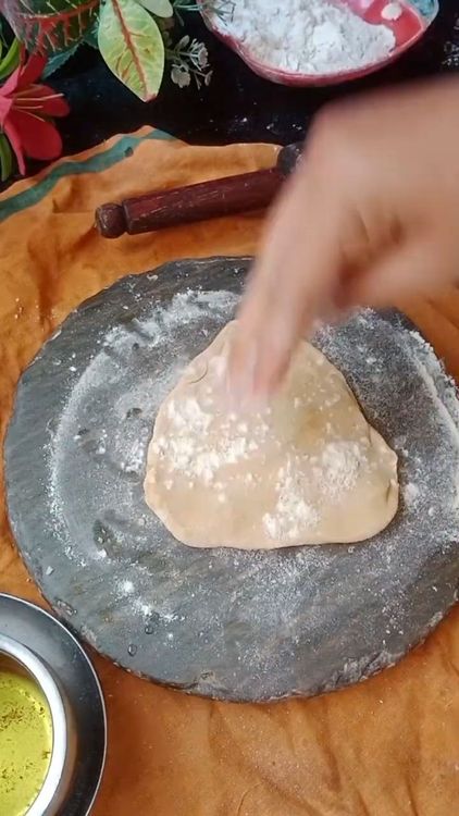 Step 2.1: Roll this triangular piece gently into a thin triangular chapati using dry flour