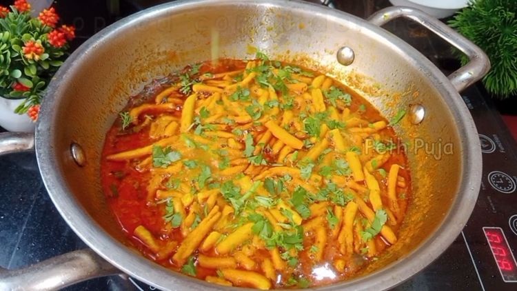 Step 2.2: Add the masala gathiya and chopped coriander leaves to the curry