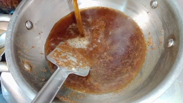 Step 1.1: Pour the jaggery syrup into the suji mixture and add green cardamom powder
